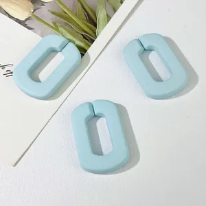 Macroweergave van drie lichtblauwe matte acryl U-vormige schakels voor DIY-accessoires.