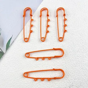Detailed view of matte orange thickened safety pins with loops for DIY jewelry charms