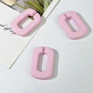 Macrodetail van roze acryl U-vormige schakels voor DIY-telefoonkettingen en hangers.
