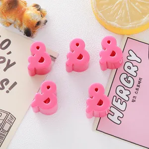 Close-up of pink ampersand acrylic beads for DIY jewelry making and crafts.