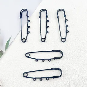 Close-up of matte black safety pins with three hanging loops for DIY jewelry projects.
