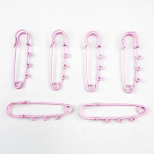 Detail shot of six large pink safety pins with four loops for DIY jewelry charms.