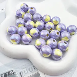 Detailed macro of iridescent purple and yellow heart print acrylic beads for DIY crafting