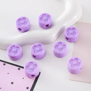 Close-up of purple acrylic beads with embossed clover pattern for DIY jewelry