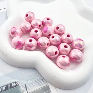 Macro view of pearlescent pink acrylic beads with printed heart patterns for DIY