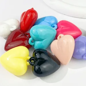 Close-up of vibrant acrylic heart pendants with hanging holes for DIY craft accessories.