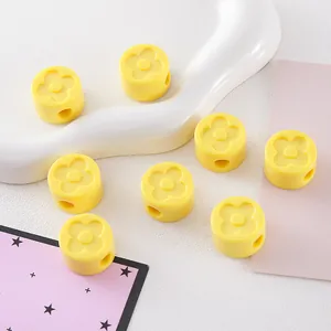 Macro detail of yellow acrylic clover-patterned beads for DIY jewelry and crafts
