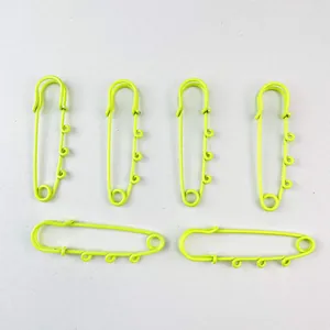 Detailed macro view of six large neon green lacquered safety pins for DIY jewelry making