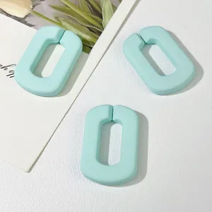 Detailopname van drie mintblauwe matte acryl U-schakels voor DIY sieraden en accessoires
