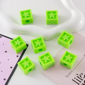 Macro view of green acrylic cube beads with embossed star design for DIY jewelry