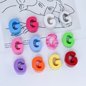 Macro view of colorful acrylic G letter beads in various shades for DIY jewelry making