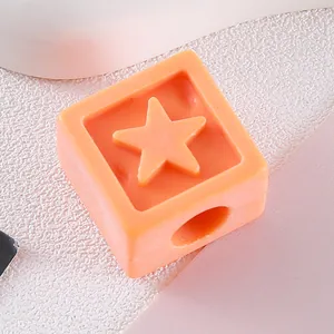 Close-up of orange acrylic cube bead with recessed star for DIY jewelry