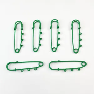 Close-up of green baked paint safety pins with decorative loops for DIY accessories