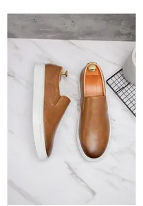 Vista superior detallada de mocasines de cuero marrón para hombre con suelas blancas gruesas