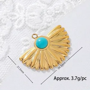 Detailed macro view of a golden fan-shaped turquoise pendant with measurement markings.