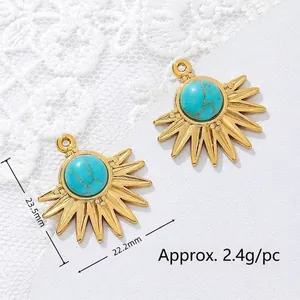 Macro detail view of two 18K gold plated sunburst charms with turquoise stone.