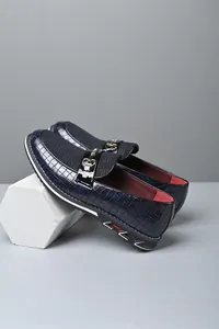 Vista lateral detallada de mocasines azules de hombre con hebilla metálica