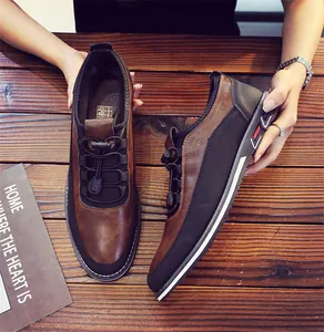 Close-up view of men's brown and black casual slip-on loafers on a wooden background
