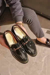 Detailaufnahme von Herren-Lack-Loafern mit klassischer Metall-Horsebit-Schnalle.