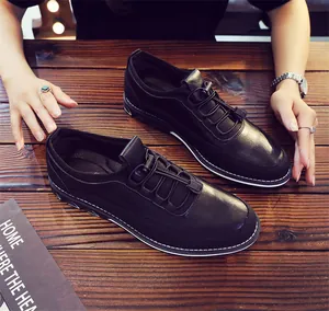 Close-up of black men's casual slip-on loafers with elastic laces on a wooden table.