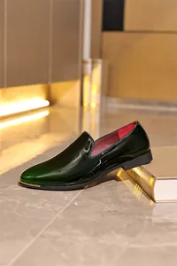 Elegant dark green patent leather men's loafers with a glossy finish and gold trim detail
