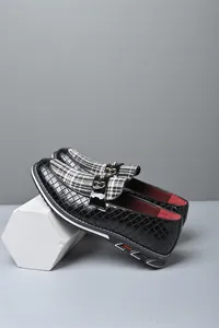 Detalle de mocasines negros premium para hombre con lengüeta a cuadros y hebilla
