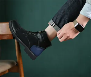 Detailed side view of men's retro black leather boots with blue stitching accents.