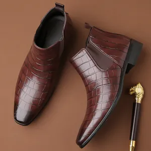 Dettaglio di stivaletti Chelsea da uomo in coccodrillo marrone con punta quadrata alla moda