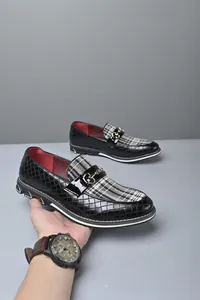 Vista detallada de mocasines negros para hombre con tela de cuadros y hebilla metálica
