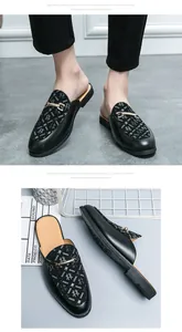 Vista detallata de mocasines de cuero negro sin talón con diseño de araña y hebilla oro