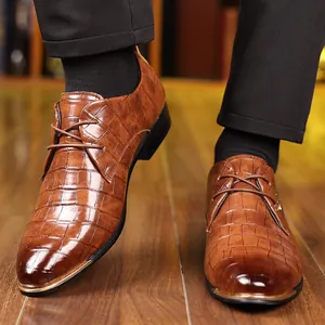 Nahaufnahme von braunen Business-Schuhen mit Krokodilmuster für Herren-Hochzeiten.