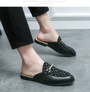 Vista detallada de mocasines masculinos de cuero negro sin talón con hebilla dorada