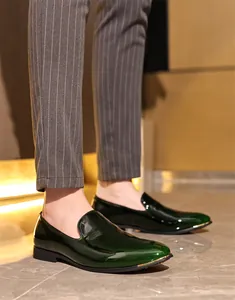 Close-up of elegant men's green patent leather loafers with gold tip detail