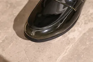 Detailaufnahme schwarzer Lackleder-Loafer mit Hochglanz-Finish und Ziernähten