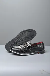 Primer plano de mocasines negros trenzados para hombre con empeine de cuadros