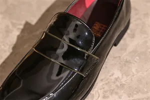 Nahaufnahme der glänzenden schwarzen Lackleder-Loafer für Herren mit feinen Stichdetails