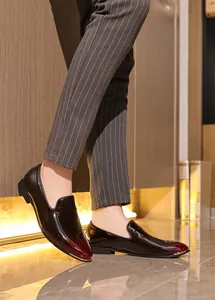 Men's patent leather loafers with gradient finish worn with striped dress pants