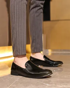 Detailed macro view of glossy black patent leather loafers for men's formal wear.