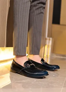 Nahaufnahme eleganter Herren-Lackleder-Loafer mit blauem Farbverlauf und Trensen-Detail