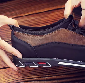 Close-up of brown and black leather men's slip-on shoes showing stitching detail