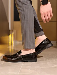Seitenansicht eleganter schwarzer Herren-Lacklederschuhe mit Metall-Trensenschnalle