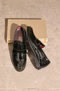 Detailansicht der polierten schwarzen Lackleder-Loafer für Herren im klassischen Business-Stil.