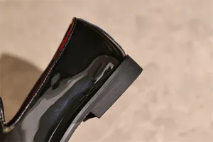 Close-up detail showing the polished heel and textured sole of black patent leather dress shoes