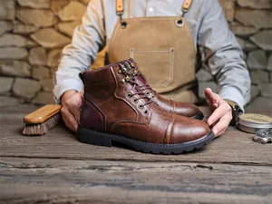 Close-up of vintage brown leather Martin boots on a craftsman's wooden workbench