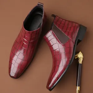 Dettaglio degli stivaletti Chelsea da uomo in pelle bordeaux con stampa coccodrillo e punta quadra