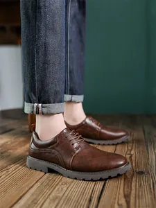 Nahaufnahme von braunen Vintage-Derby-Lederschuhen für Herren auf rustikalem Holzboden.