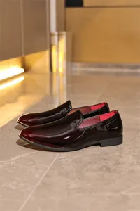 Detailed view showing high-gloss burgundy patent leather on men's formal slip-on loafers