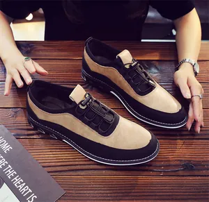 Detailed top view of men's brown and black slip-on loafers on a wooden table