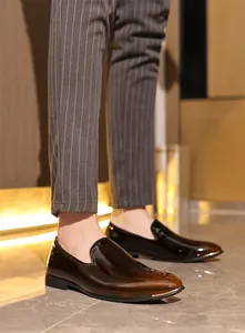 Close-up of premium glossy brown men's slip-on loafers with metallic toe detail