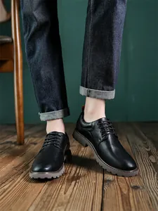 Nahaufnahme von schwarzen Derby-Schuhen für Herren im Vintage-Stil auf Holzfußboden